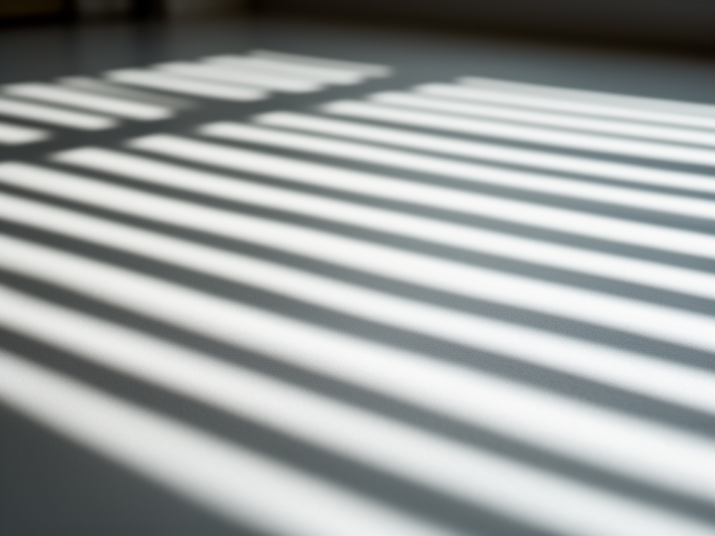 Abstract photograph of light and shadow patterns through venetian blinds creating rhythmic lines across a calm interior surface